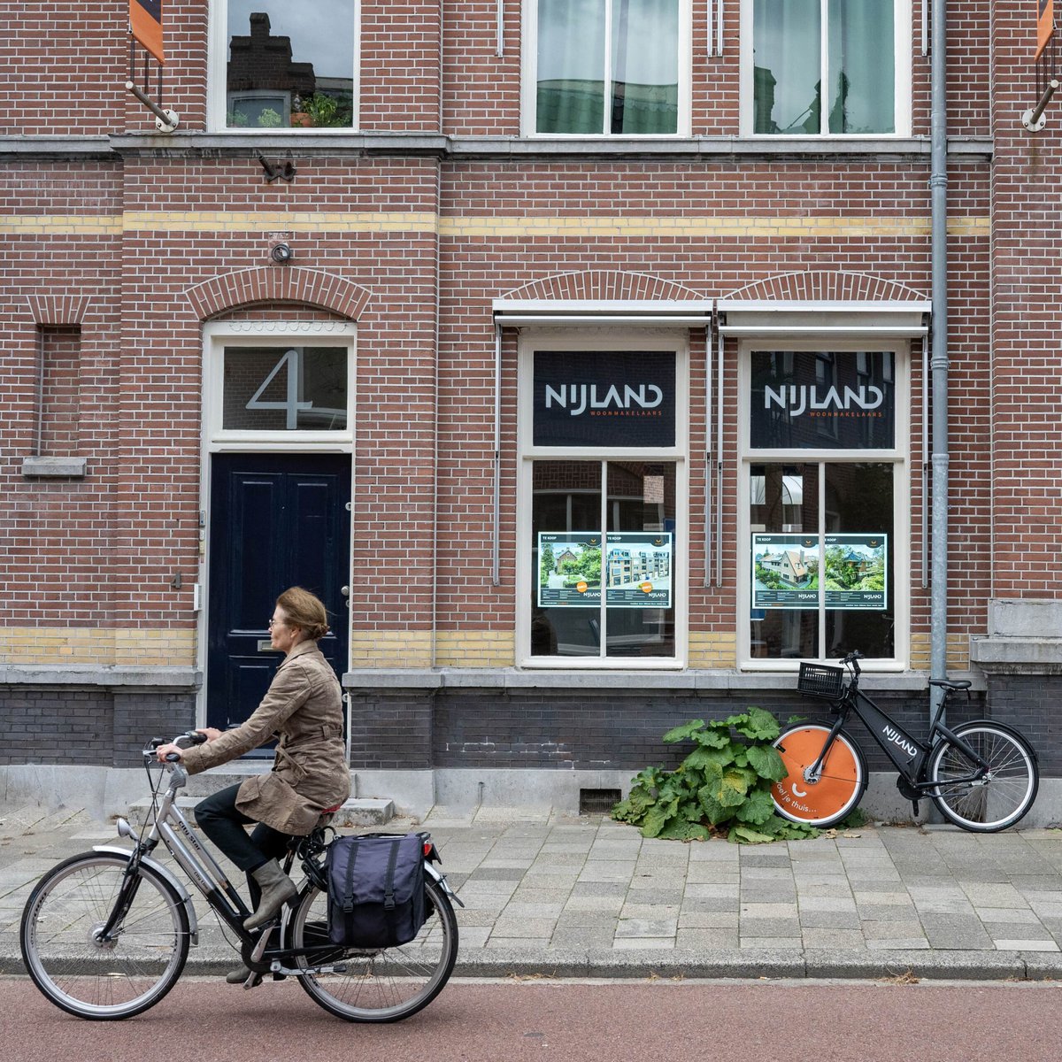 fietsers langs de narrowcasting van Nijland Makelaars